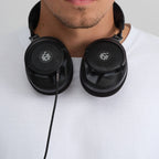 Adam Audio H715 Reference headphones worn around the neck, lifestyle shot