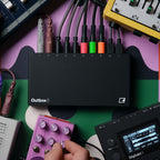 Elektron Outbox 8 patched on a desk beside a Digitakt II and pedals